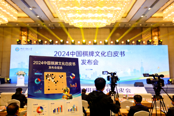 《2024中国棋牌文化白皮书》发布会现场，报告海报陈列在舞台前方的照片